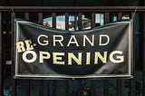 A (re-)grand opening sign — photo by Tim Mossholder