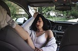 Gorgeous woman resting against the steering wheel inside a car