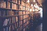 A book shelf full of books and enlightened by bubble lights all the way to the end