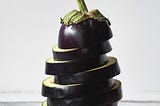Artfully sliced eggplant in a stack with a whit background