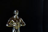 A gold trophy that looks like an Oscar. However, it is of a slightly different design where the figure has different features and is holding a laurel instead of a sword.