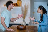 A couple arguing in the kitchen.