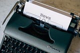Olympia typewriter with sheet of paper inserted. The word ‘News’ is typed at the top of the paper.