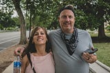 Older American couple walking on the sidewalk smiling