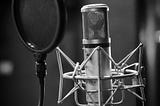 Black and white professional microphone with pop filter.