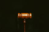 A gavel at the centre of a black background