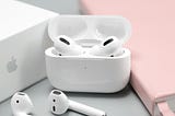Airpods! Flanked by a pink notebook and the Apple product box.