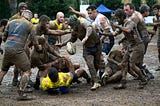 A group of rugby players competing in muddy conditions.