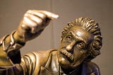 Bronze statue of Albert Einstein observing motion on a string with his finger as a balance.