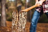 An axe splits a tree trunk