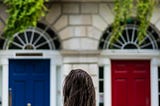 a woman is in front of a blue and red door and feels she must choose