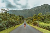 A girl walking through a Tropical country road