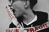 A yelling person taped to a wall. The tape reads “fragile.”