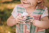Small child with messy painted face and hands