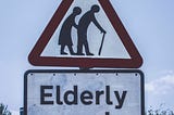 the picture of the couple , backs bent, man with walking stick warning traffic of elderly folks