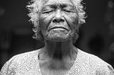 An elderlywoman closes her eyes