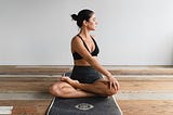 A woman stretching on a yoga mat at home.