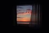 Sunset through the window of a darkened room