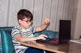 Young boy starting programming on a laptop