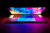 partially open laptop bathed in glowing colors