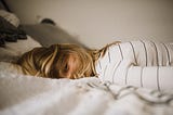 Woman suffering from burnout lying on the bed.