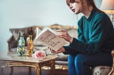 A women reads a book while sitting in the sopha