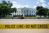 The White House is pictured in the background with yellow tape in the foreground that reads, Police Line — Do Not Cross.