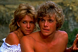 Kristy McNichol holds a shirtless Christopher Atkins from behind in a still from The Pirate Movie