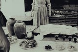 A lady ghost in a kitchen.