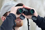 Man staring through binoculars.