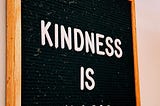 Black board with white letters that spell Kindness Is Magic