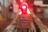A red light bulb illuminated above a sign reading “good records”