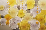 a display of accordion fold paper flowers (or possibly the tops of umbrellas) in shades of yellow