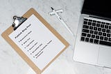 Image of a checklist for publishing a blog post with a pen and a Macbook