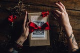 a book wrapped as a gift with a red bow