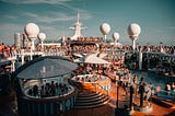 Many travelers gathered around enjoying and relaxing on the open deck on a cruise