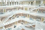 Big 4 story library full of shelves with books on them.