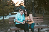 Two women laughing on a park bench.