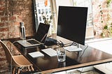 Image of a desk with a laptop and monitor