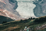 Someone looking up at a glacier.