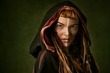 Beautiful red-headed medieval woman in a cape and hood