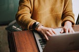 Person typing on a silver computer