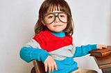 A cut little girl wearing play-like glasses, acting like an adult.