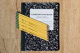 A composition book with pencils