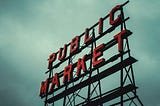 Sign of the Public Market against a cloudy sky in Seattle, WA.
