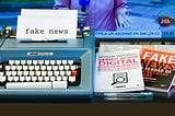 A typewriter and books teaching how to create fake news for digital media