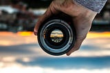 a lens in the foreground correcting an upside-down blurry image in the background