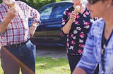 Two older people enjoying an ice cream.