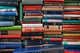 Old books stacked with their spines facing us