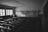 a black and white photo of an empty classroom